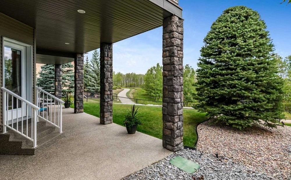 Covered front porch of a home near the Sheep River pathways in Okotoks, sold by TJ Hart-Anderson